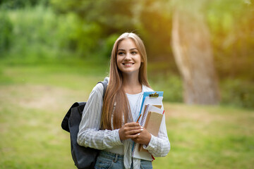 Freshman Girl. Beautiful Female College Student With Workbooks And Backpack Posing Outdoors