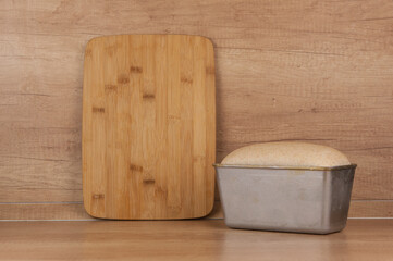 Homemade toasted whole wheat bread and metal form for bread on wood table