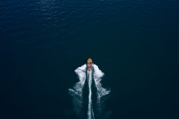 Classic Italian motor boat. Top view of a wooden boat sailing to the blue sea. Wooden runabout in...