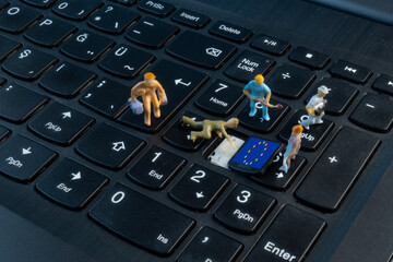 Mini Workers working on EU flag on top of keyboard