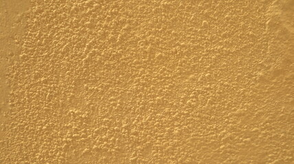 A Yellow cement wall is suitable for making a background.