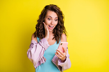 Photo of astonished lady arm on cheek open mouth look phone new blog subscribe isolated on yellow color background