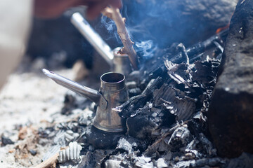 Coffee in turk cooked on coals. Traditional bedouin coffee in Egypt. Selective focus.