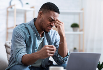 African Man Massaging Nosebridge Tired After Work On Computer Indoors