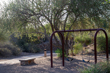 Swing set in a park next to a walking path