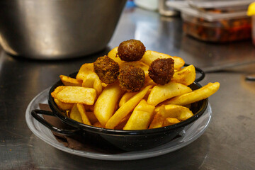 Porzione di patatine fritte con polpettine di carne 