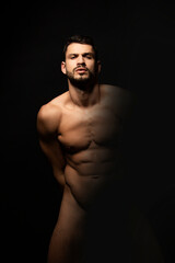 Fototapeta na wymiar Handsome sport sexy stripped guy portrait on isolated black background