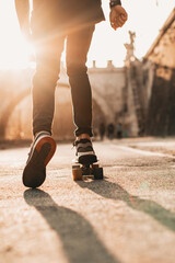 detail of legs and feet on the skate at sunset near an urban bridge