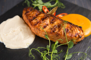 Grilled salmon fillet in sour cream sauce decorated with sprouted wheat