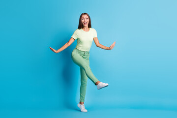 Fototapeta na wymiar Full length photo of sweet charming young woman wear green outfit dancing isolated blue color background
