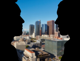 Zwei Geschäftsleute im Profil vor Los Angeles Skyline © Robert Kneschke