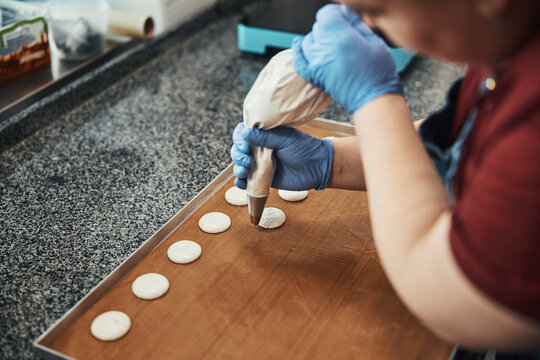 Busy pastry chef making even circles of icing