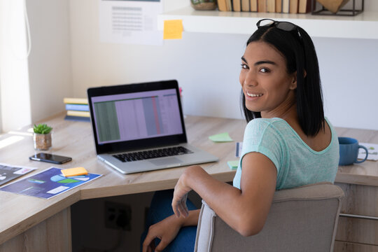 Mixed race transgender female working at home using laptop