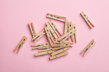  Wooden clothespins on pink background, laundry concept top view