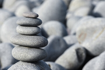 Fototapeta na wymiar Pebble stack on the beach the stones represent balance and wellbeing of the mind