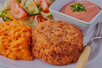 Homemade fishcake with salad and seafood sauce.