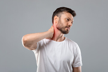 Middle aged bearded man touching his inflammated neck