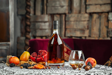 Elegant bottle of cognac with fruits on the table