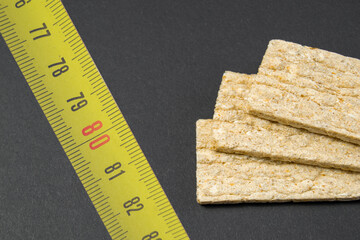 weight loss with proper nutrition. Healthy food. Puffed dietetic crisps lie on a black background....