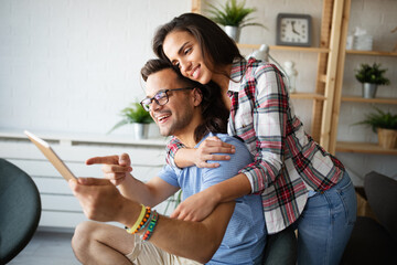 Young couple sitting in the living room and using tablet.