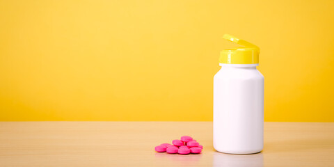 A white jar with scattered red pills on a yellow background.