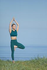 Woman doing yoga at the sea