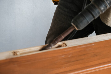Carpenter working on wood cutting machine during wooden door furniture manufacturing