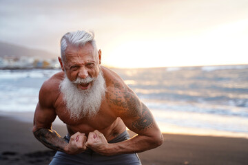 Fit and muscular senior man exercising on the beach. In a healthy body, healthy mind.
