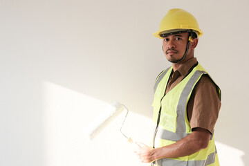 Painter man holding with painting roller in white room