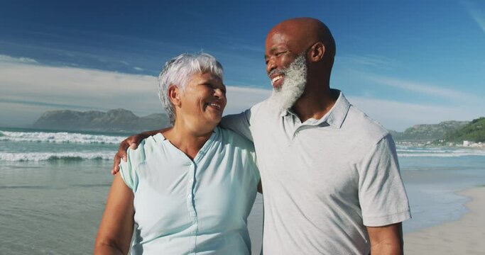 Smiling senior african american couple embracing at the beach