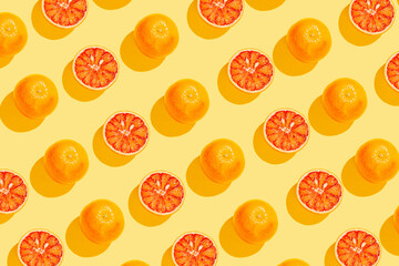 Creative pattern made with  blood orange on yellow background. Summer fruit   concept. Minimal style. Sunlit flat lay. Top view