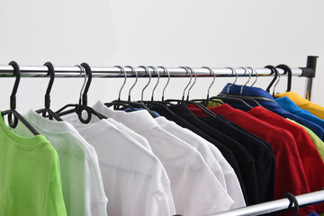 Shirts, T-shirts, clothes on hangers in the wardrobe or clothing store