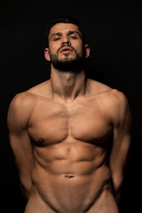 Fototapeta premium Handsome sport sexy stripped guy portrait on isolated black background