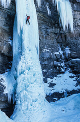 An ice climber solo climbing an ice pillar in Colorado, USA