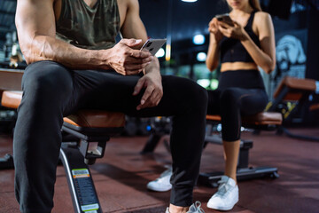 Fototapeta premium Member in Fitness gym using smartphone technology planing workout, Healthy Lifestyle bodybuilding, Athlete builder muscles lifestyle, Coach training online concept.