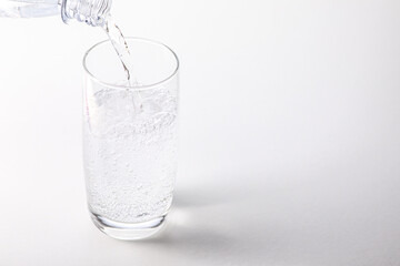 Wasserglas mit PET Flasche beim Eingießen
