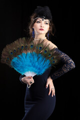 Retro woman portrait. Beautiful girl with a fan in the style of the 20s or 30s. Old fashionable...