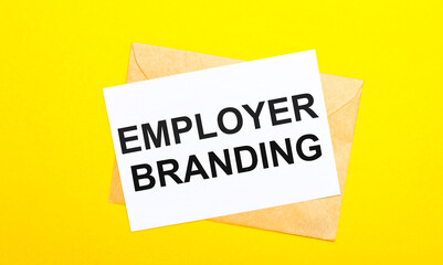 On a yellow background, an envelope and a card with the text EMPLOYER BRANDING. View from above