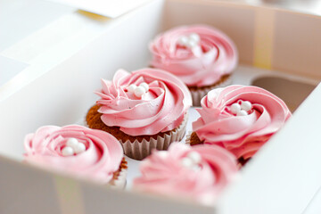 pink strawberry cupcakes inside a white box