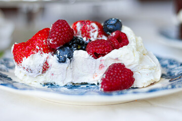 Pavlova cake with meringue, cream and red berries