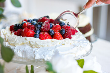 Pavlova cake with meringue, cream and red berries