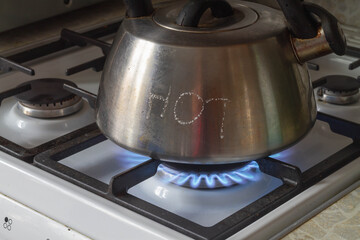 Water boils in a steel kettle on the gas stove in the kitchen