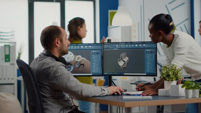 Black employee and project manager analysing mechanical metalic parts, 3D cad program with gears shape, software with new prototypes. Industrial engineer and afro colleague working in creative office