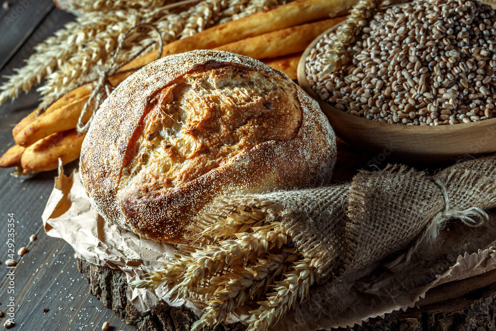 Wall mural bread, traditional sourdough bread cut into slices on a rustic wooden background. concept of traditi