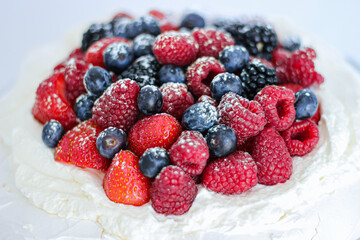 Pavlova cake with meringue, cream and red berries