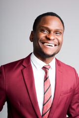 Portrait of a happy african american man in a shirt and red jacket who smiles broadly while looking at the camera