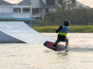 Asian young child boy wake boarding