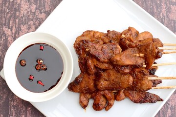 Sate Ayam or Chicken satay or Chicken skewers. Indonesian food. Served with thick soy sauce and chili 