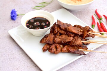 Sate Ayam or Chicken satay or Chicken skewers. Indonesian food. Served with peanut sauce, thick soy sauce and chili 