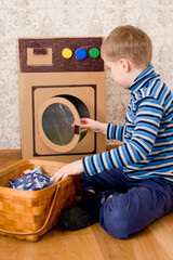 laundry service. kid doing laundry with homemade corrugated cardboard washing machine.